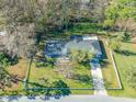 Aerial view of a well-maintained home featuring a long driveway and surrounded by a white picket fence at 11201 Knotty Pine Dr, New Port Richey, FL 34654