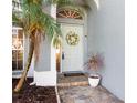The home's entrance features a decorative wreath, brick pavers, and a well-kept flowerbed at 1600 Gray Bark Dr, Oldsmar, FL 34677
