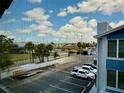 Beautiful view of the parking lot, blue skies and some palm trees from a screened lanai at 169 Medallion Blvd # E, Madeira Beach, FL 33708