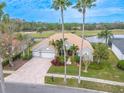 Beautiful single-story home on golf course with lush landscaping, a tile roof, and water views at 12113 Marblehead Dr, Tampa, FL 33626