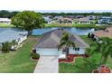 Aerial view showcasing a home on the water with a well-maintained lawn at 609 Fort Duquesna Dr, Sun City Center, FL 33573
