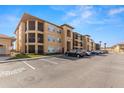 Exterior view of condo building with screened balconies, well-maintained landscaping, and ample parking at 4345 Bayside Village Dr # 304, Tampa, FL 33615