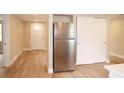 Open kitchen area with stainless steel refrigerator, wood-look floors, and a large closet at 7160 Lenape Cir, New Port Richey, FL 34653