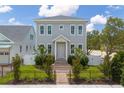Inviting two-story home with a manicured lawn, white picket fence, and charming brick walkway at 100 37Th Ne Ave, St Petersburg, FL 33704