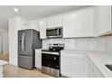 Modern kitchen features white cabinets, stainless steel appliances, and a light counter top at 12811 Wanderlust Pl, Parrish, FL 34219
