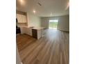Open-concept kitchen and living space with modern appliances and luxury vinyl plank flooring at 2754 Pearly Banks Dr, Bradenton, FL 34208