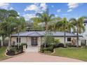 Charming single-story home featuring lush landscaping, a brick driveway, and a modern front door at 2115 S West Shore Blvd, Tampa, FL 33629