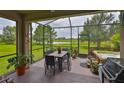 Screened patio with outdoor furniture, hot tub, and view of lush backyard and water at 6516 Salt Creek Ave, Apollo Beach, FL 33572