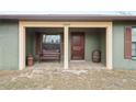 Inviting covered front porch with decorative bench, barrel, and stained wood door at 12404 Dolquieb Ln, Weeki Wachee, FL 34614