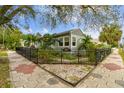 Corner lot with a black metal fence, lush tropical landscaping, and unique patterned sidewalk at 487 9Th N Ave, St Petersburg, FL 33701