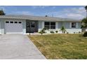 Charming single-story home with attached garage, driveway, manicured lawn and decorative white window shutters at 123 9Th St, Belleair Beach, FL 33786