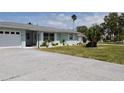 Beautiful one-story home featuring a large driveway, attached garage, well-manicured lawn and updated windows at 123 9Th St, Belleair Beach, FL 33786