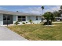 Beautiful one-story home featuring a large driveway, well-manicured lawn, updated windows and green exterior at 123 9Th St, Belleair Beach, FL 33786