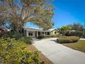 Charming home featuring a metal roof and lush landscaping with a curved concrete driveway at 6723 Mango S Ave, St Petersburg, FL 33707