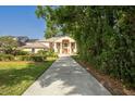 Stately home featuring a circular driveway, manicured landscaping, and a grand entrance with classic architectural details at 11710 N Armenia Ave, Tampa, FL 33612