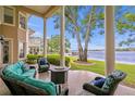 Relaxing covered patio with comfortable seating, beautiful lake views, and lush greenery, perfect for outdoor entertainment at 11710 N Armenia Ave, Tampa, FL 33612