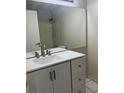 Bathroom showcasing a modern vanity with white countertop, large mirror and tile flooring at 3332 Vorden St, New Port Richey, FL 34655