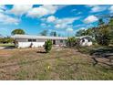 Exterior view of single-story home with white brick facade, windows, and flat roof amid a lawn with trees at 6666 Pinellas Point S Dr, St Petersburg, FL 33712