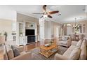 Spacious living room with hardwood floors, ceiling fan, and built-in entertainment center at 4936 Sandy Brook Cir, Wimauma, FL 33598