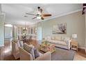 Bright living room features hardwood floors, ceiling fan, neutral paint, and dining area access at 4936 Sandy Brook Cir, Wimauma, FL 33598