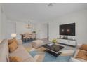 Bright, open-concept living and dining area featuring a modern chandelier and a large television at 5004 Sandy Brook Cir, Wimauma, FL 33598
