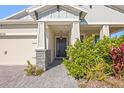 Charming home entrance with a black front door, stylish stone pillars and professionally landscaped foliage at 6232 Sea Air Dr, Apollo Beach, FL 33572