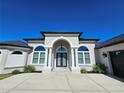 Beautiful home with arched entryway, decorative columns, and meticulously maintained landscaping at 11199 Warm Wind Way, Weeki Wachee, FL 34613