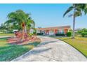 Stunning single-story home boasts a terracotta roof, lush landscaping, and a winding driveway at 1575 Brookside Blvd, Largo, FL 33770