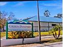 Green Dolphin Villas Condo Complex Sign with lush landscaping and well-maintained exterior buildings at 1250 S Pinellas Ave # 713, Tarpon Springs, FL 34689