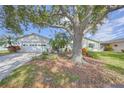 Charming single-story home with an attached garage, a well-manicured lawn, and mature trees at 1318 Leland Dr, Sun City Center, FL 33573
