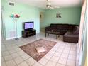 Cozy living room with tile flooring, a comfortable sofa, and a ceiling fan for added comfort at 255 114Th N Ave # 4, St Petersburg, FL 33716