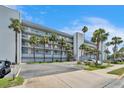Condo complex showcasing tropical landscaping, parking, and multiple floors with balconies at 18325 Gulf Blvd # 407, Redington Shores, FL 33708