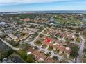 Aerial view of a residential neighborhood with a golf course and waterfront views in the distance at 2267 Heron Cir, Clearwater, FL 33762
