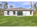 Expansive backyard with lush lawn, sliding glass doors, and bright natural light for outdoor enjoyment at 4546 Padgette St, North Port, FL 34291