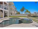 Outdoor pool and hot tub with tropical landscaping and waterfront access for boating at 17059 Dolphin Dr, North Redington Beach, FL 33708