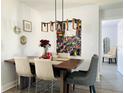 Dining room with rectangular wood table, modern light fixture, and accent wall decor at 4684 25Th S Ave, St Petersburg, FL 33711