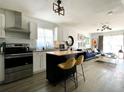 Open concept kitchen and living space with island, stainless steel appliances, and blue sofa at 4684 25Th S Ave, St Petersburg, FL 33711
