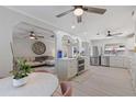Open-concept kitchen with stainless steel appliances, white cabinetry, and an adjacent living area at 8716 Hickorywood Ln, Tampa, FL 33615