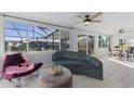 Bright sun room features stylish seating, white plank ceiling, and a view of the screened outdoor pool at 8716 Hickorywood Ln, Tampa, FL 33615