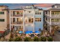Luxury coastal home featuring multi-level balconies, a private pool, and stylish outdoor seating at 8750 Harrell Ave, Treasure Island, FL 33706