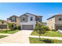 Attractive two-story home with a well-maintained lawn and a two-car garage at 16719 Delia St, Wimauma, FL 33598