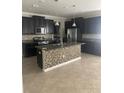 Modern kitchen with black cabinets, stainless steel appliances, granite countertops and decorative tile backsplash on the island at 2588 Bartolo Dr, Land O Lakes, FL 34639