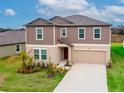 Two-story house with a two-car garage, landscaped front yard, and charming architectural details at 11307 Linden Depot Rd, San Antonio, FL 33576