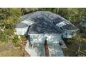 Birds eye view of the home, showcasing the roof, two-car garage, manicured landscaping, and mature trees at 12411 Cavalier Ct, Hudson, FL 34669