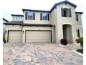 Charming two-story home features a three-car garage and brick-paved driveway at 12854 Boggy Creek Dr, Riverview, FL 33579