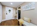 Inviting foyer with wood floors, a white door with floral decor, and a decorative bench at 36750 Us Highway 19 # 21-301, Palm Harbor, FL 34684