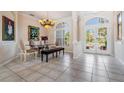 Bright dining room featuring tile floors, glass table, and view of front yard at 394 Tall Oak Trl, Tarpon Springs, FL 34688