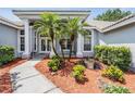 Inviting home entrance featuring double doors, columns, and decorative landscaping at 394 Tall Oak Trl, Tarpon Springs, FL 34688