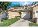 Attractive townhouse with an attached single-car garage, neutral stucco, and well manicured yard at 8907 Casablanca Way, Tampa, FL 33626