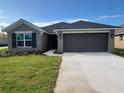 Inviting single-Gathering home featuring a well-kept lawn and a two-car garage at 13290 Ogden Glade Rd, Dade City, FL 33525